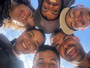 Group smiling in a selfie on the beach at Ilha do Francês in Florianópolis after a kayak tour