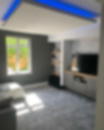 Modern living room with television, shelves, grey walls and Carpets.