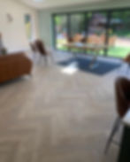 Herringbone pattern Hard Wood Flooring in a modern living room with chairs.