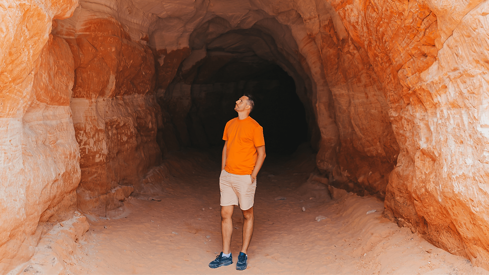 A man stainding at the mouth of the Belly of the Dragon tunnel in Southern Utah