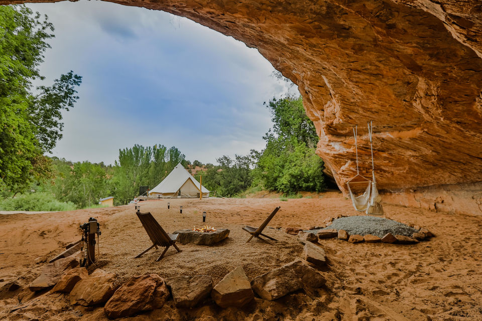 Cave alcove seating area with hammock and desert surroundings.