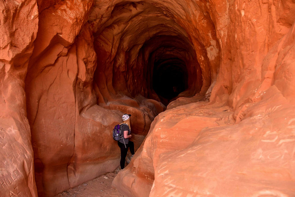 Woman hiking through the Belly of the Dragon Tunnel in Southern Utah