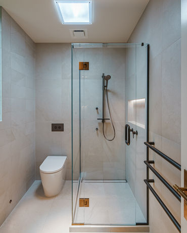 A brand new bathroom installed, featuring a shower and in-wall cistern and toilet, as part of the Takapuna house renovation.