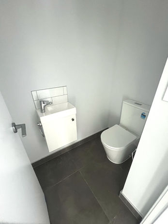 Brand new toilet room with toilet and sink.