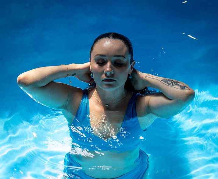 gril in the water wearing a blue bathing suit