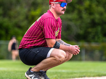 Adult baseball player crouching on field