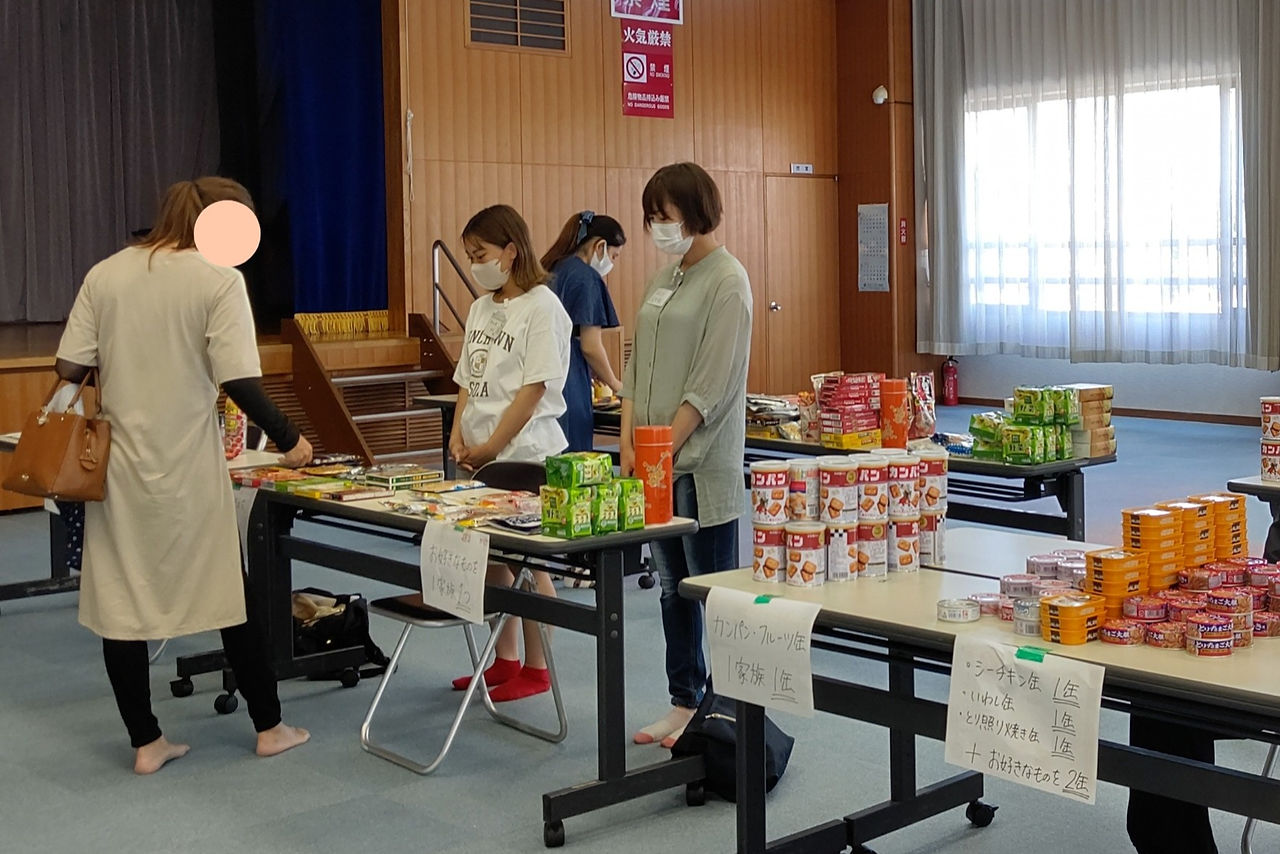 調味料コーナーで来場されたひとり親さんと会話するボランティア