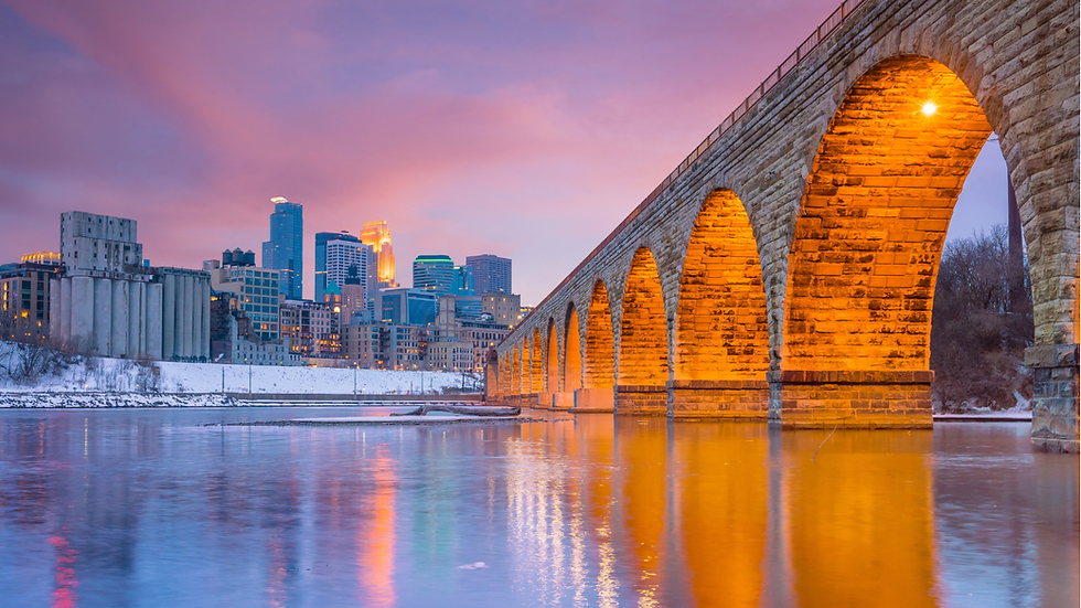 Stone Arch bridge and Minneapolis skyline at sunset