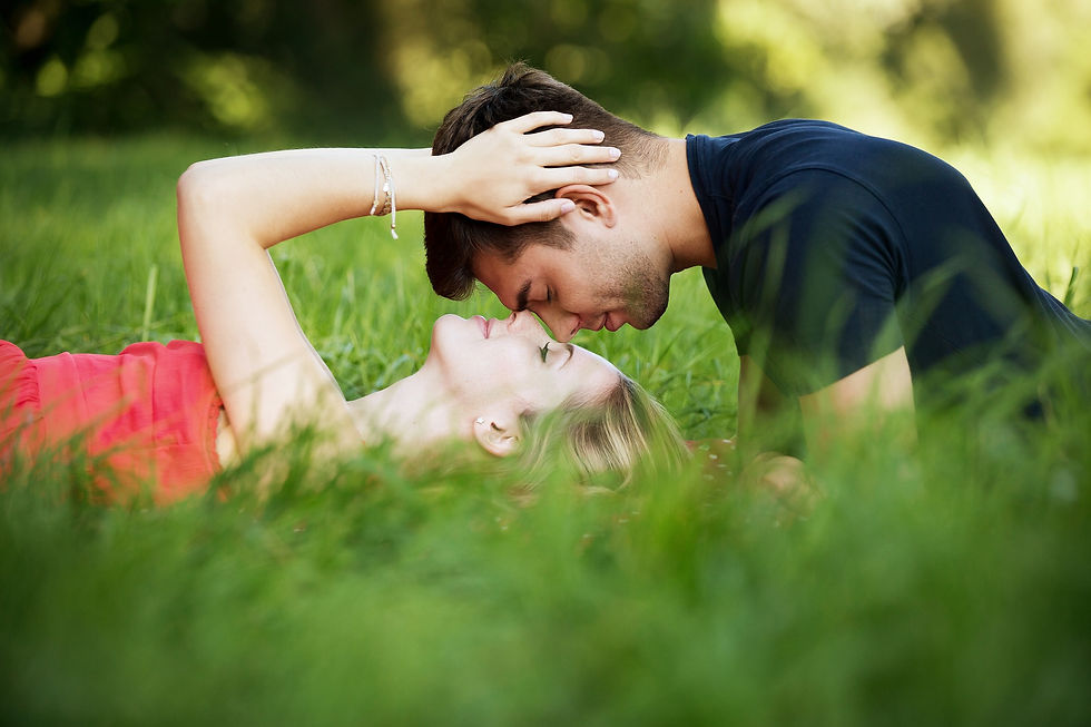 Beautiful couple lying in grass noses touching