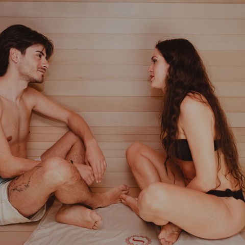 Two guests relaxing together in a wooden sauna; illustrative stock photograph