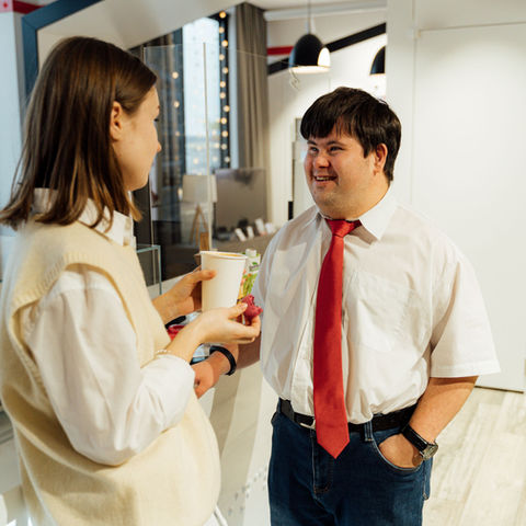 Hospitality manager and team member discussing service standards in a cafe
