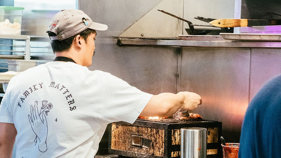 A chef preparing food at a commercial kitchen range