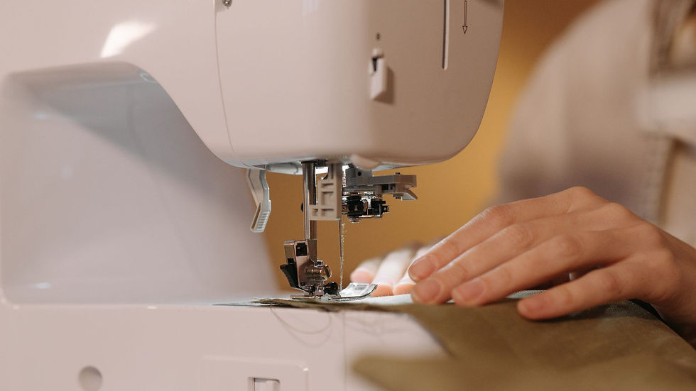 Hands guiding fabric through a sewing machine
