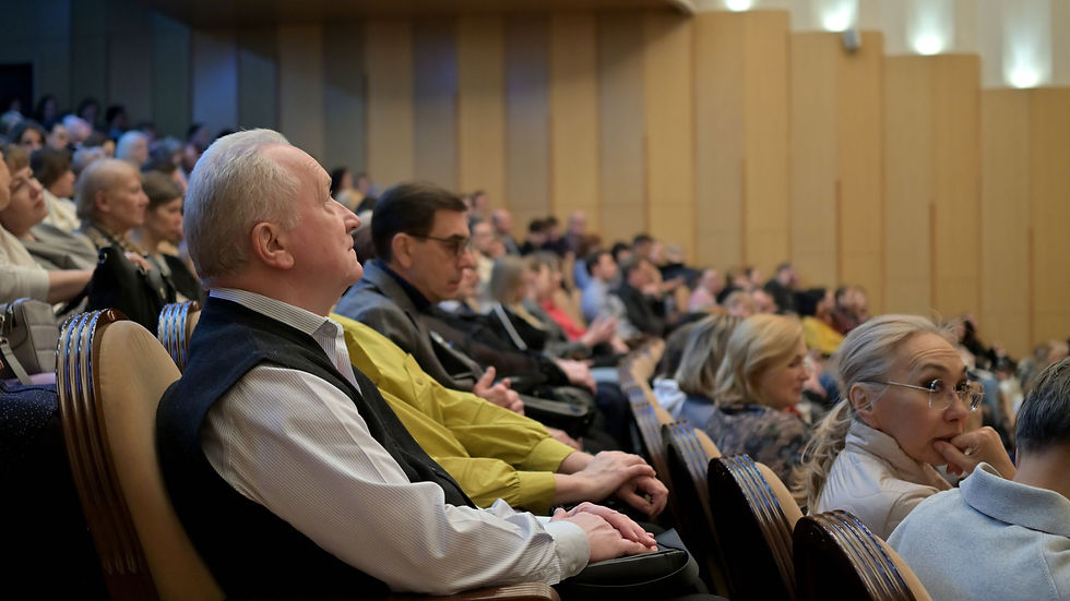 Seated audience listening in a conference hall; illustrative stock photograph