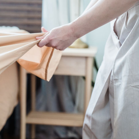 Hotel housekeeper making a guest bed with fresh linen