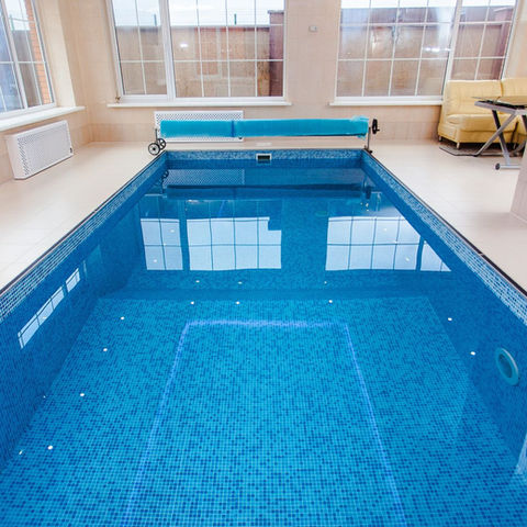 Indoor swimming pool with loungers beside the water