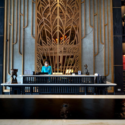 Premium hotel reception team speaking with a guest