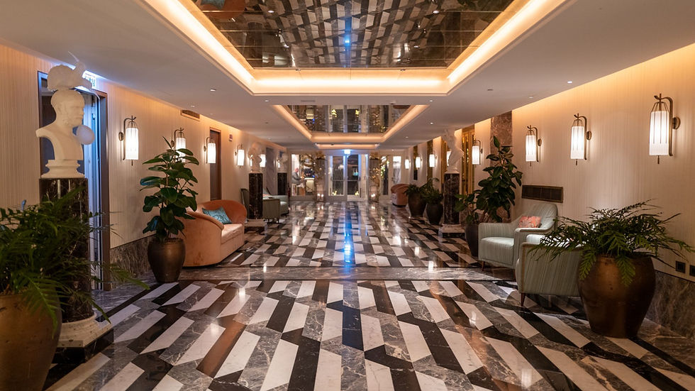 A polished hotel corridor with decorative arches and plants; illustrative stock photograph