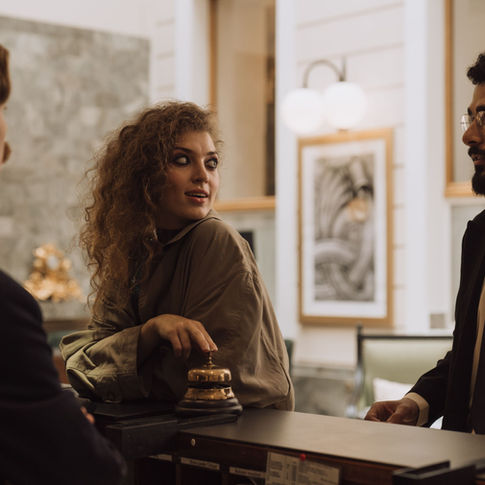 Guests speaking with hotel staff at a reception desk