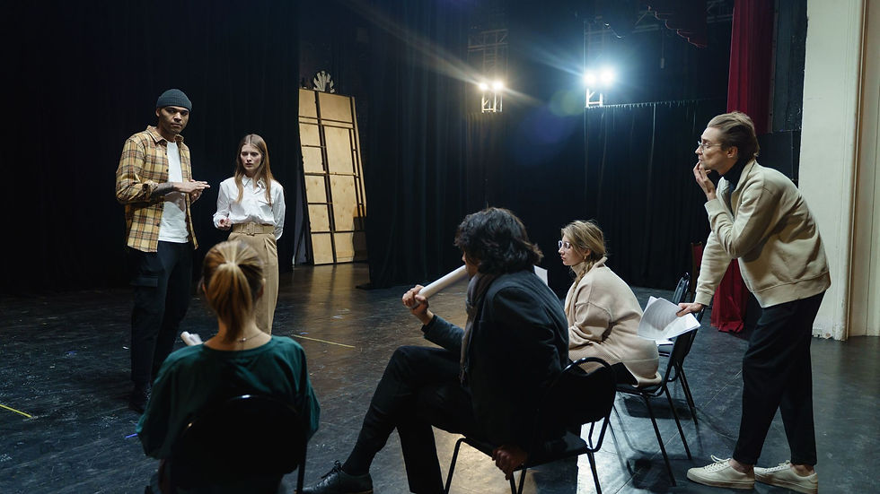 Rehearsal group listening to colleagues explain an activity on stage