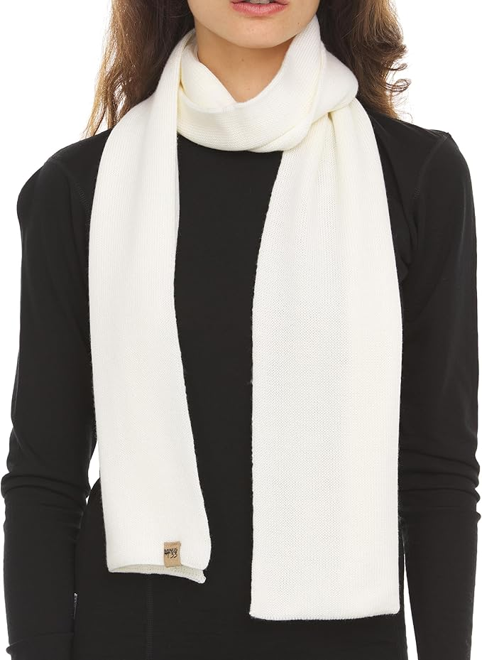 Woman wearing a black long-sleeved shirt wearing a white merino wool scarf.