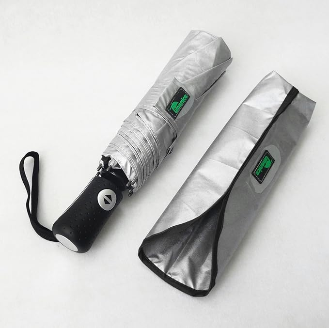 Silver foldable Umenice umbrella with black handle and strap beside its matching case on a white background. Green logo visible on both.