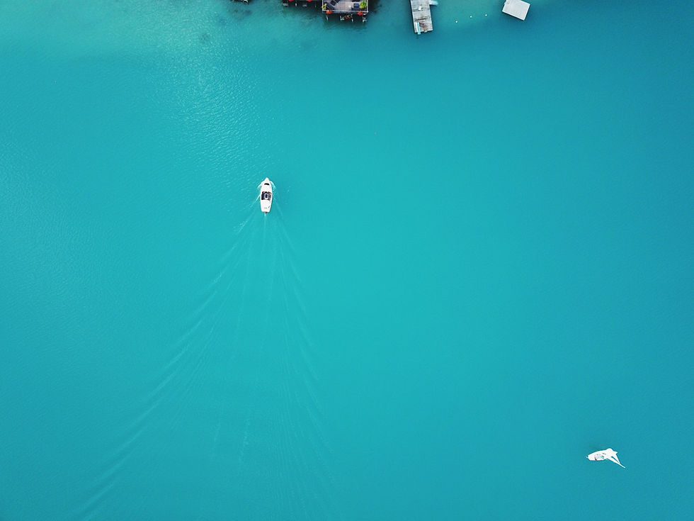 Dies ist ein Hintergrundbild für die Webseite, dort ist ein blaues Meer zu sehen mit einem kleinen Boot.