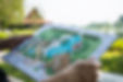 paper sheet of layout plan with hands and garden background, that shown design of clubhous