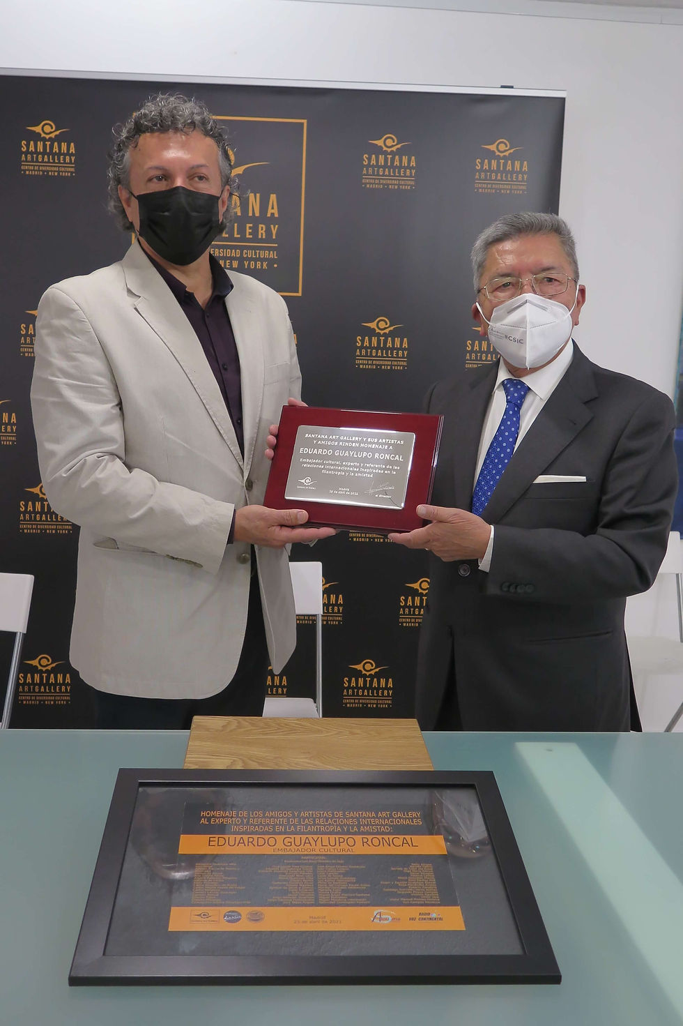 El director Miguel Santana entrega la placa de plata al homenajeado Eduardo Guaylupo