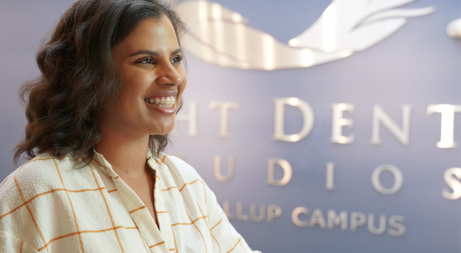 Customer posing in front of LDS logo.