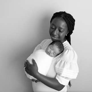 mom holds her newborn for family photos