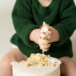 closeup photo of one year old grabbing cake for his first birthday 