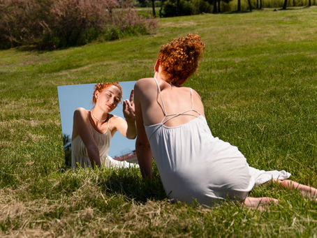 mulher cansada emocionalmente se olhando no reflexo do espelho