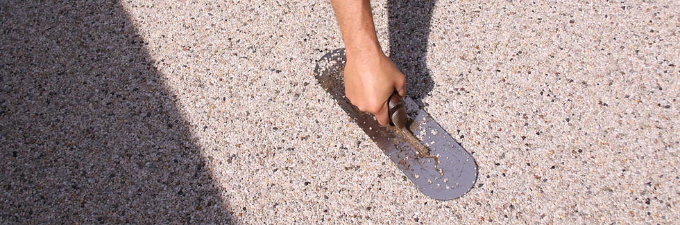 RonaDeck resin bound surfacing being trowelled down by an installer onsite.