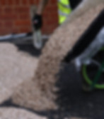 RonaDeck resin bound surfacing resin and aggregates being poured onto a tarmac floor to be installed.