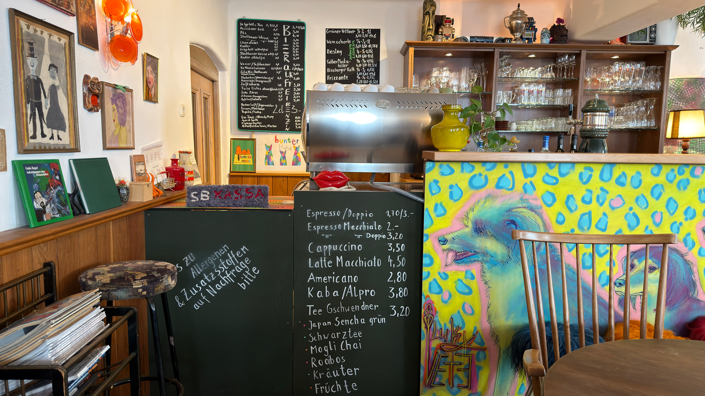 Gemütliches Café mit Theke, Kaffeemaschine und bunter Thekenkunst