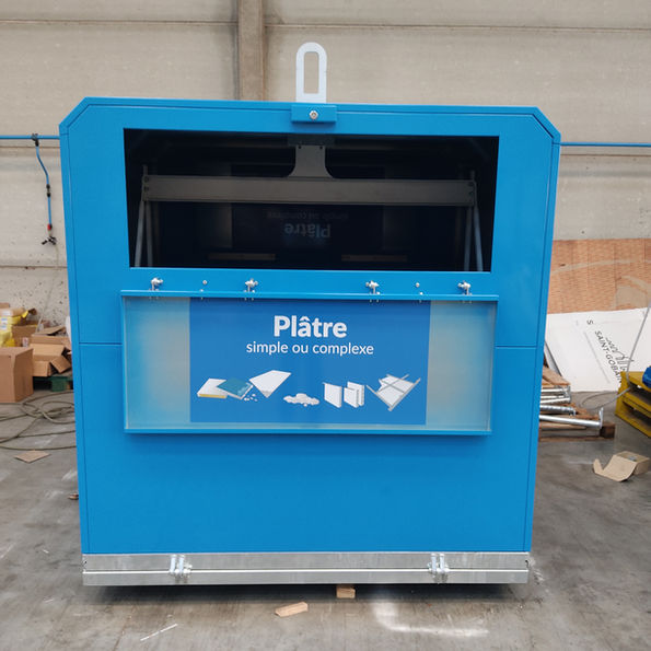 Borne de collecte pour déchets de chantier, installée sur un site en plein air, utilisée pour trier gravats, bois, et matériaux recyclables.