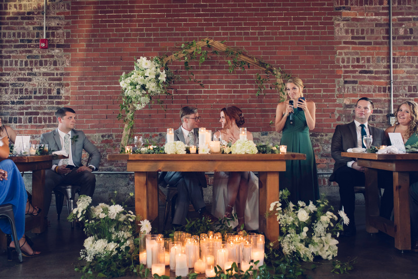 head table with candles on ground and arch