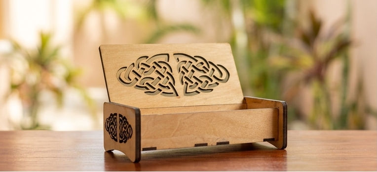 Small wooden jewelry box with an intricate Celtic knot design.