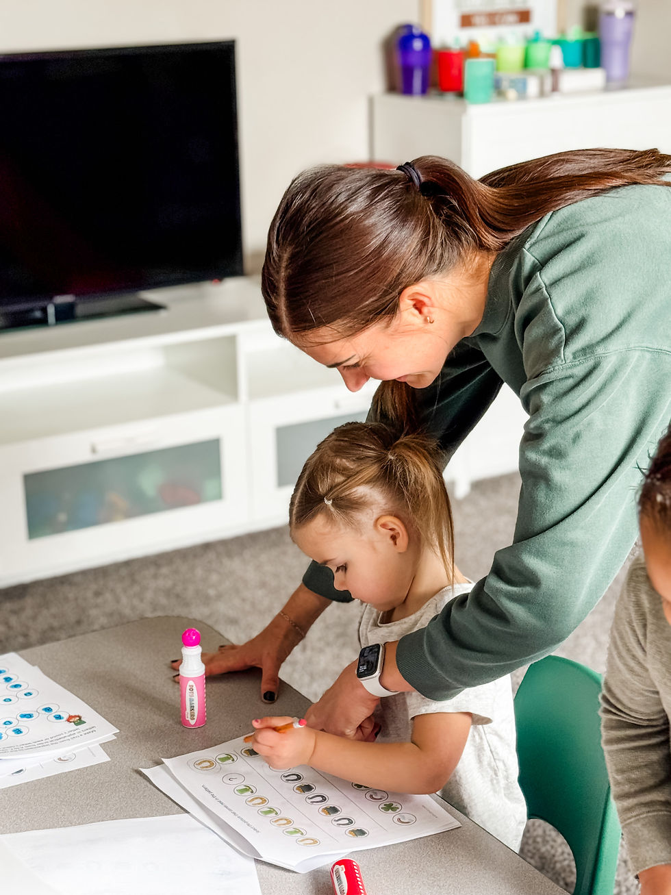 Teacher helping a child with activities at a Provo daycare.
