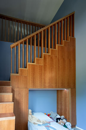 Trapkast in een kinderkamer die de vide toegang biedt gemaakt van kersenfineer