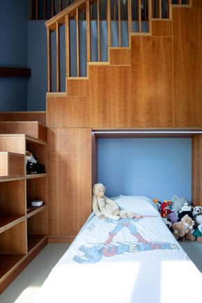 Trapkast in een kinderkamer die de vide toegang biedt gemaakt van kersenfineer