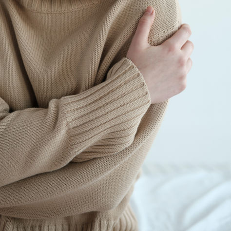Photo of a Woman in a Beige Sweater Hugging Herself - Plant Based for Life Nutritionist