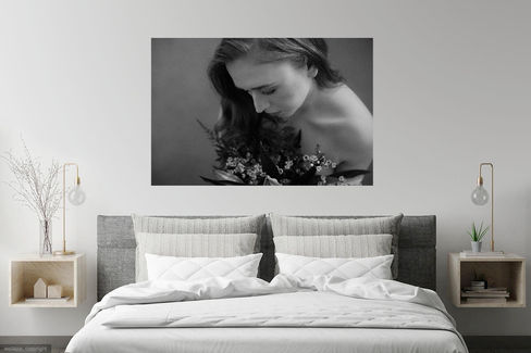 Large black & white portrait of a woman on the wall above a bed