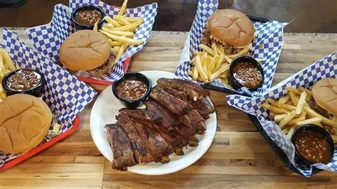 Plate of food from Arnold’s BBQ & Grill in Memphis, Tennessee, featuring a slab of slow‑smoked ribs glazed with barbecue sauce alongside a juicy hand‑patted cheeseburger with fries.