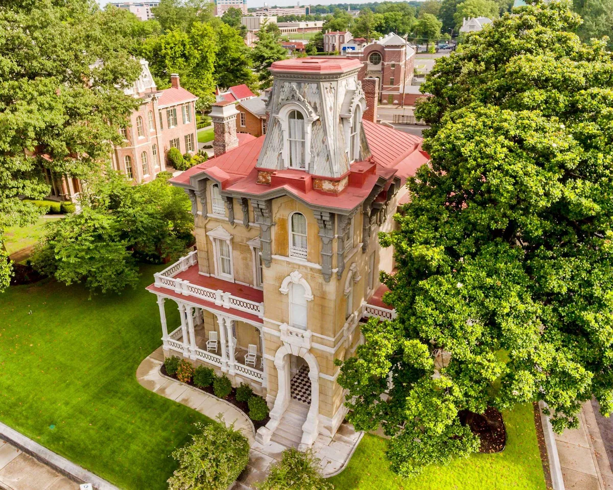 Exterior of The James Lee House in Memphis, Tennessee, a restored 19th‑century Victorian mansion with ornate Second Empire architecture, mansard roof, arched windows, and grand front entrance in the historic Victorian Village district.