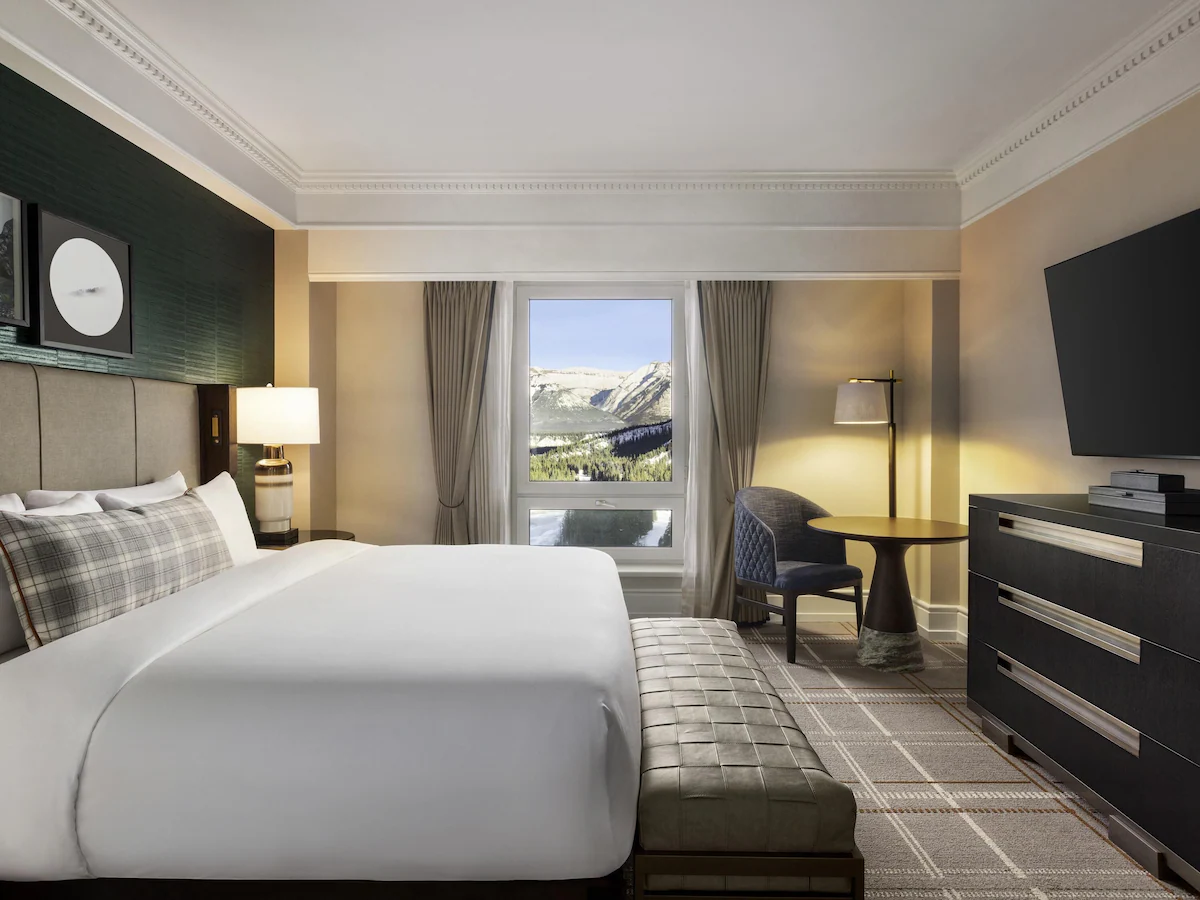 Guest room at the Fairmont Banff Springs Hotel in Banff, Alberta, featuring elegant décor, plush bedding, large windows with mountain views, and a blend of historic charm with modern luxury.