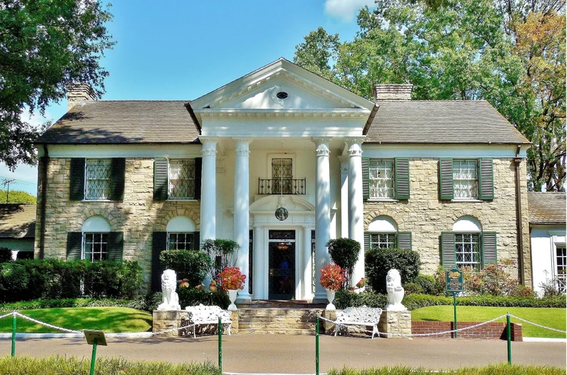 Exterior of Graceland Mansion in Memphis, Tennessee, Elvis Presley’s iconic Southern‑colonial style home with white columns, limestone façade, and manicured front lawn.