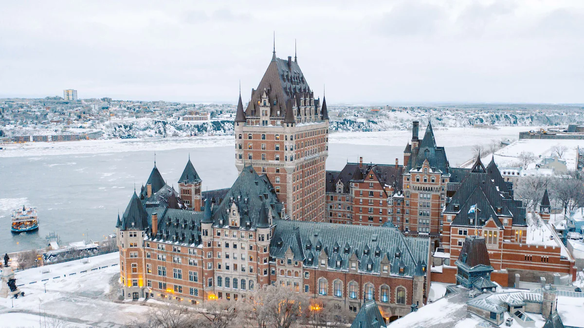 Exterior of Fairmont Le Château Frontenac in Quebec City, a grand château-style hotel with copper turrets, steep rooftops, and stone façade overlooking the St. Lawrence River.