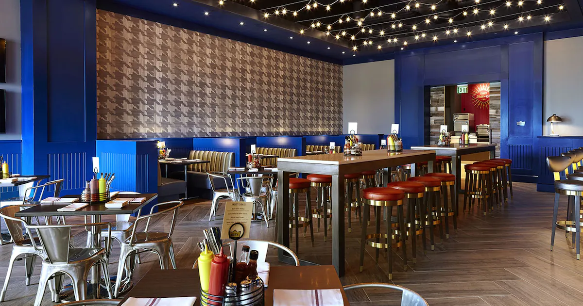 Dining at The Guest House at Graceland in Memphis, Tennessee, featuring elegant Southern‑inspired décor, white‑tablecloth settings, and guests enjoying meals at Delta’s Kitchen, the hotel’s signature restaurant.